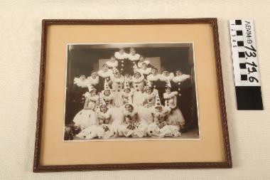 Φωτογραφία με κορνίζα - φωτογραφία, σε ξύλινη κορνίζα, στην οποία απεικονίζεται μια ομάδα καρναβαλιστών (πιερότοι) στην Ξάνθη,τέλη δεκαετίας 1920