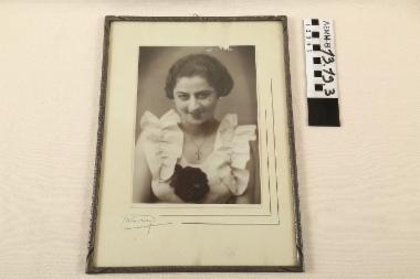 Φωτογραφία με κορνίζα - φωτογραφία, σε ξύλινη κορνίζα, στην οποία απεικονίζεται η μητέρα της δωρήτριας σε νεαρή ηλικία