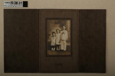 Φωτογραφία - φωτογραφία σε εκτύπωση σέπια και τρίφυλλη, χάρτινη καφέ κορνίζα, απεικονίζονται τρία μικρά παιδιά