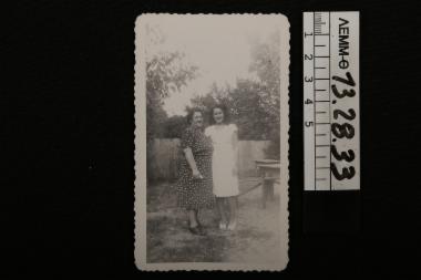 Φωτογραφία - ασπρόμαυρη φωτογραφία, στην οποία απεικονίζονται δύο γυναίκες σε αυλή