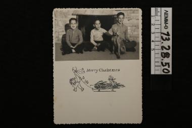 Ευχητήρια κάρτα - χριστουγεννιάτικη κάρτα με ασπρόμαυρη φωτογραφία στην οποία απεικονίζονται τρία παιδιά με ένα σκυλί, 1960
