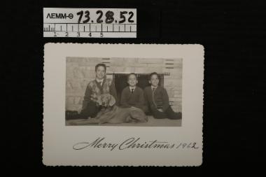 Ευχητήρια κάρτα - χριστουγεννιάτικη κάρτα με ασπρόμαυρη φωτογραφία στην οποία απεικονίζονται τρία παιδιά με ένα σκυλί, 1962
