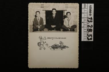Ευχητήρια κάρτα - χριστουγεννιάτικη κάρτα με ασπρόμαυρη φωτογραφία στην οποία απεικονίζονται τρία παιδιά μπροστά από το τζάκι, 1961