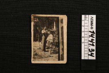 Φωτογραφία - ασπρόμαυρη φωτογραφία (κιτρινισμένη) , απεικονίζει τον Ευστράτιο Σάκκη να κουρεύει ένα μαθητή του