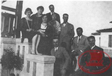 Aretsou. Mr. Bakirtzis, Mr. Diamantopoulos, Mr. Kondekakis, and Mrs. Syrou, Mrs. Theodosiadou, and Mrs. Kallitsi on the veranda of the Syrou mansion