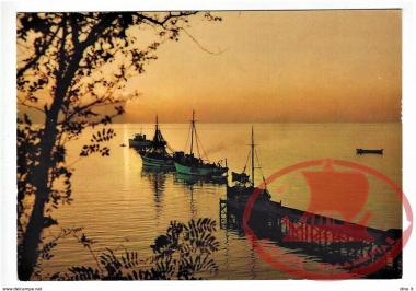 Sunset at the beach of Nea Krini with the boats and the wooden stairs.