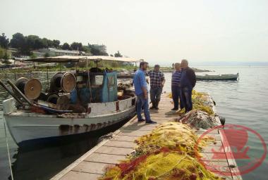Η ξύλινη πλωτή σκάλα της Νέας Κρήνης με τους αλιείς να συζητάνε και στην στεριά κάτω η Ταβέρνα ‘’Χάρκας’’, επάνω στον βράχο το κέντρο ‘’Ρέμβη’’.