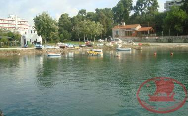 The coast of Nea Krini, with its small harbour, the building of the Agia Paraskevi Association and its small church.
