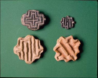 Λίθινες νεολιθικές σφραγίδες από τα Φάρσαλα (πάνω αριστερά), την Πύρασσο (πάνω δεξιά), και τον Αλμυρό (οι δύο κάτω, με μαίανδρο).