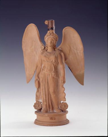 Πλαστικό αγγείο σε σχήμα φτερωτής γυναικείας πεπλοφόρου.