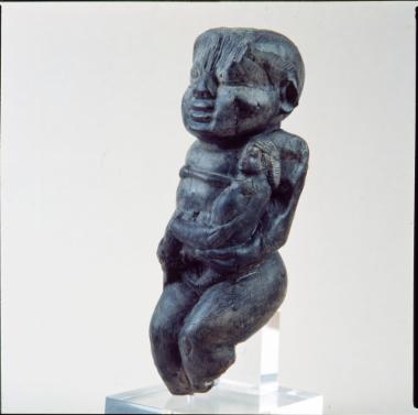 Ξύλινο αγαλμάτιο δαιμονικής ανδρικής μορφής στον τύπο του Bes, που κρατά γυμνή ανδρική μορφή