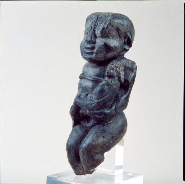 Ξύλινο αγαλμάτιο δαιμονικής ανδρικής μορφής στον τύπο του Bes, που κρατά γυμνή ανδρική μορφή