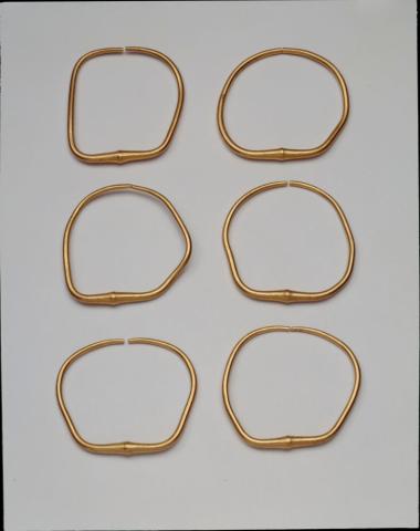 Έξι όμοια χρυσά βραχιόλια.