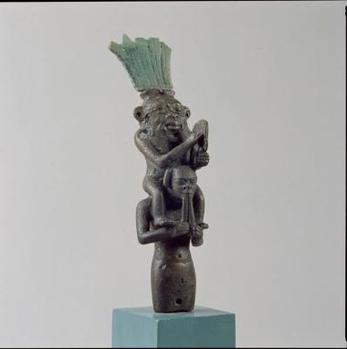 Αιγυπτιακό χάλκινο ειδώλιο του δαίμονα Bes, που κάθεται στους ώμους μουσικού που παίζει διπλό αυλό