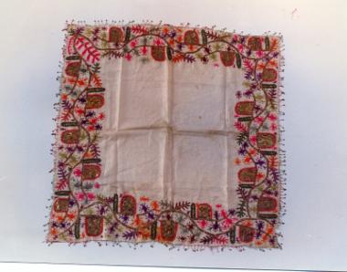 Τετράγωνο μαντίλι με διακόσμηση τεβρέ, από βαμβακομέταξο ύφασμα διακοσμημένο περιμετρικά με πολύχρωμα ανθικά μοτίβα
