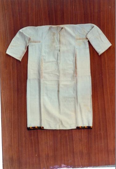 Λευκό βαμβακερό πουκάμισο.Φέρει στο κάτω μέρος του πολύχρωμη διακόσμηση. Θράκη.