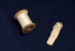 Handbag, brown leather with cherry lining and zip, containing small purse and sewing cotton