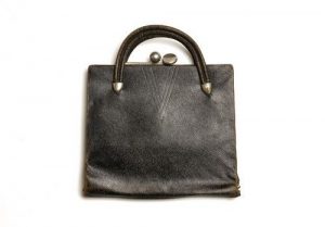 Handbag, black leather with cream lining, inserted purse, metal clasp, leather string and handle