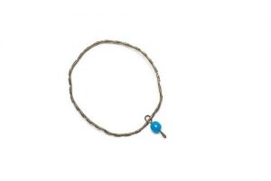 Child's metal bangle with blue plastic bead.
