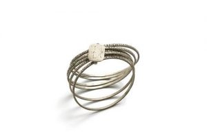 Five silver bangles linked with clasp inscribed with 'AM'.