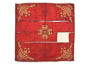 Wrapper, mahagony orange atlas silk with laid and couched gold embroidery, central floral ornament and corner motifs.