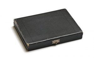 Cardboard case, black, with blue satin lining. It belonged to Elias Dekastro.
