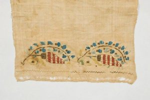 Repeated floral design embroidered with red and gold silk.