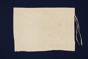 Crude white cotton with two sewn strings, inner wrapper of Torah scroll (?).