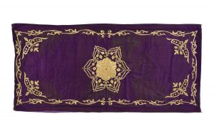 Dark purple silk with gold embroidery, central ornament, corner motifs and foliate border, used for Brit Milah ceremony.