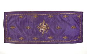 Purple silk with gold embroidery in couching technique, central ornament and foliate border, used for the honorary seat of the Hatan Torah (Bridegroom of the Torah).
