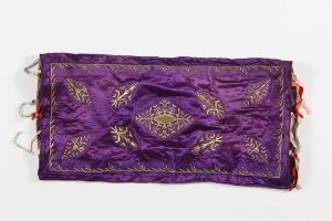 Purple silk with laid and couched gold embroidery, central floral ornament, corner motifs and foliate border, ribbon ties at both ends, probably belonged to the local Jewish community.
