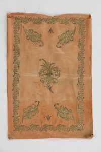 Apricot silk satin with laid and couched gold embroidery, central blossoming branch, diagonally placed corner motifs, bordered by wavy line interrupted by sprays.