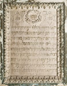 Stone plaque commemorating a financial donation of 100 Napoleon gold coins by Moshe HaCohen in memory of his wife Leah, from the Synagogue of Preveza.