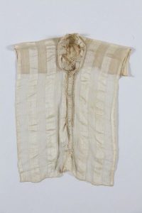 Cream linen with vertical silk stripes, button-facing and collar with needle lace edging, probably belonged to a member of the the local Jewish community.