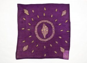 Purple silk with gold embroidered cut-outs in secondary use, possibly used as a cover.