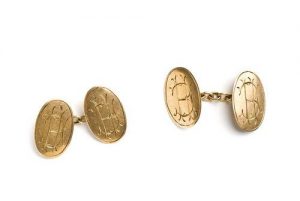 Gold locket with initial inscribed on the outer face.