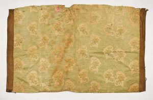 Cover for Tik (Torah case) or reader' desk (?), cream silk brocade with horizontal green stripes and floral pattern, edged with brown fabric.