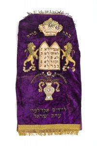 Torah mantle, violet velvet, embroidery and applique work, motifs depicting a flower vase, Tablets of the Covenant with flanking lions and the Corwn of the Torah, dedicated by Adat Israel Congregation (New York ?).