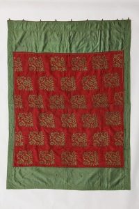 Torah ark curtain, red silk centrepiece with laid and couched gold embroidery, repeated floral bunches, dark mint green silk border stripes, with suspension rings.