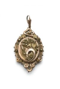 Oval gold locket with scroll decoration.