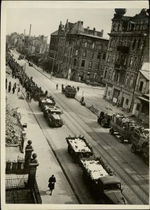 Street in Hannover, Germany, trucks with murdered Russian prisoners move towards burial ground.
