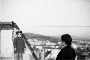 Young girl and a woman on the terrace of a building.