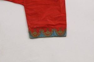 Woman's baggy trousers, red silk, ankle cuffs with scalloped edge embroidered with gold cord, underlaid by azure blue silk strips, embroidery detail.
