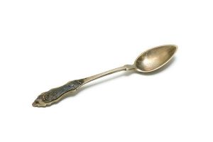 Silver spoon with filigree decoration on handle.