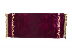 Eggplant violet velvet with gold embroidered floral borders and gold fringe trim on both sides, in secondary use.