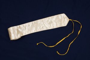 Narrow white satin band with white cotton lining and yellow tie.