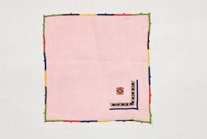 Pink linen tea towel with colourful embroidery and edging, from Salonika.
