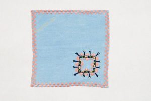 Light blue linen tea towel with colourful embroidery and edging, from Salonika.