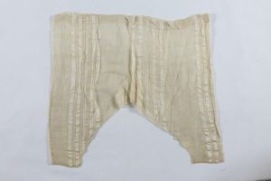 Cream silk with vertical stripes, with drawstring fastening, edged with crochet lace at ankle cuffs, probably belonged to a member of the the local Jewish community.