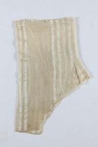 Cream silk with vertical stripes, with drawstring fastening, edged with crochet lace at ankle cuffs, folded, probably belonged to a member of the the local Jewish community.